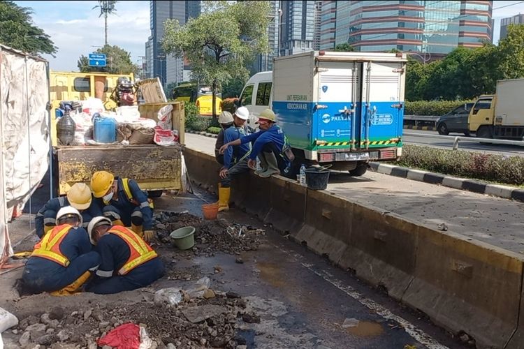 Petugas PT PAM Lyonnaise Jaya (Palyja) tengah memperbaiki kebocoran pipa air PAM di Jalan Gatot Subroto atau tepat di depan Kementerian Investasi/BKPM pada Sabtu (29/10/2022).