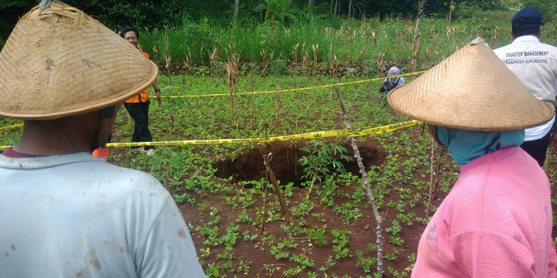 Sakino dan Istrinya melihat petugas BPBD Gunung Kidul melakukan pemeriksaan lubang di lahan miliknya di Dusun Pringwulang, Desa Bedoyo, Kecamatan Ponjong.