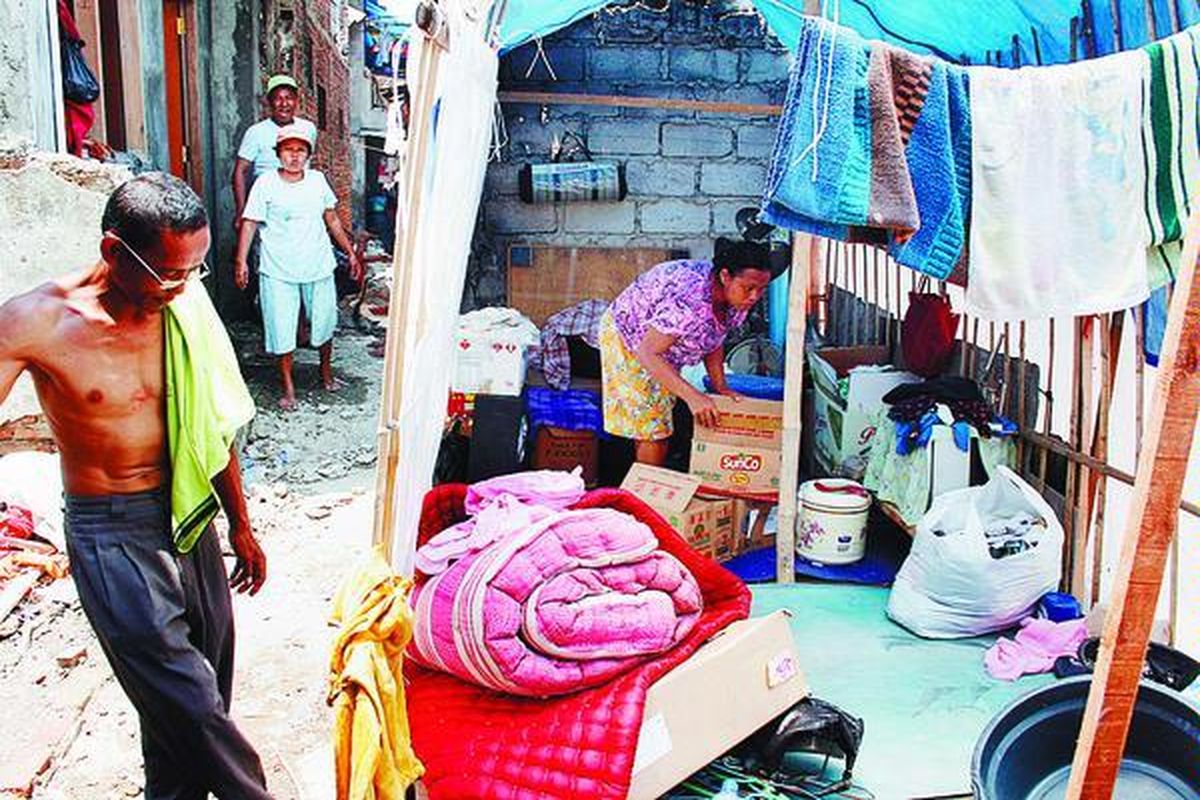 Suherman (35) dan keluarganya masih menempati tenda sementara yang didirikan di bekas rumahnya yang terbakar di RT 3 RW 12 Penjaringan, Jakarta Utara, Minggu (18/10). Sebagian keluarga terpaksa menempati kolong Jalan Tol Wiyoto Wiyono saat hujan turun karena rumah mereka belum selesai dibangun.