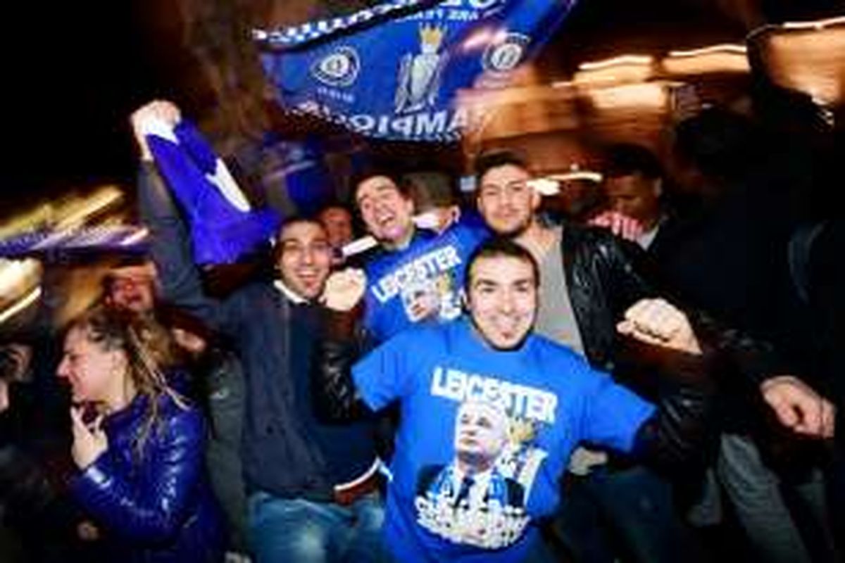 Suporter Leicester City merayakan keberhasilan tim mereka menjuarai Premier League 2015-2016. Leicester memastikan gelar seusai Tottenham Hotspur bermain imbang 2-2 dengan Chelsea, Senin (2/5/2016). 