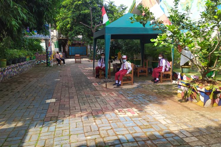 Siswa SDN Lebak Bulus 04 Pagi menunggu dijemput di bawah tenda ruang tunggu dengan bangku yang berjarak, Senin (30/8/2021) 