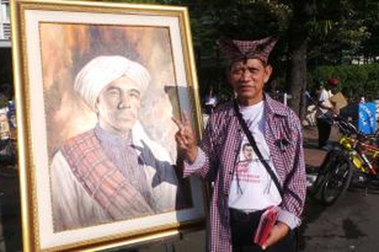 Lukisan calon presiden Joko Widodo mengenakan sorban putih dipamerkan dalam acara Car Free Day di bundaran Hotel Indonesia, Jakarta, Minggu (22/6/2014).