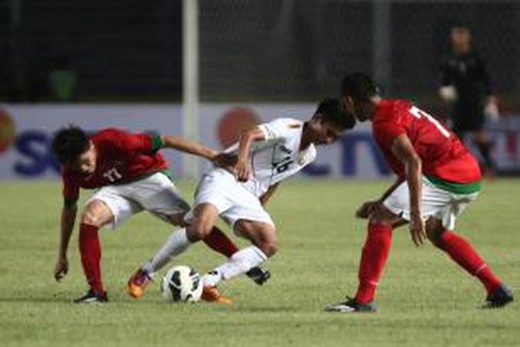 Pemain Timnas U-19 Indonesia, Paulo Oktavianus Sitanggang (kiri) dan Muhammad Dimas Drajad berusaha menghentikan laju pemain U-19 Myanmar, Chit Hla Aung pada pertandingan persahabatan di Stadion Gelora Bung Karno, Jakarta, Senin (5/5/2014). Kedua tim bermain imbang 1-1.