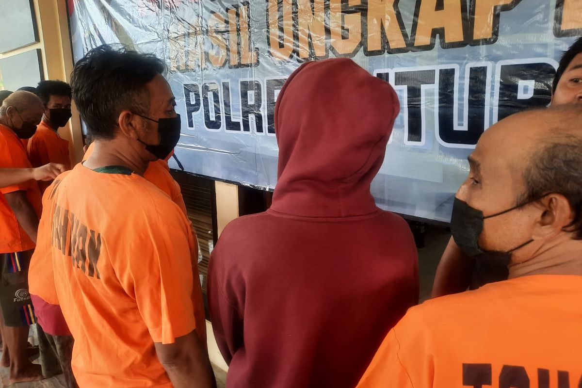 Foto: Perempuan tersangka kasus pornografi berjaket merah ketika dipamerkan di Mapolres Situbondo pada Kamis (13/4/2023).