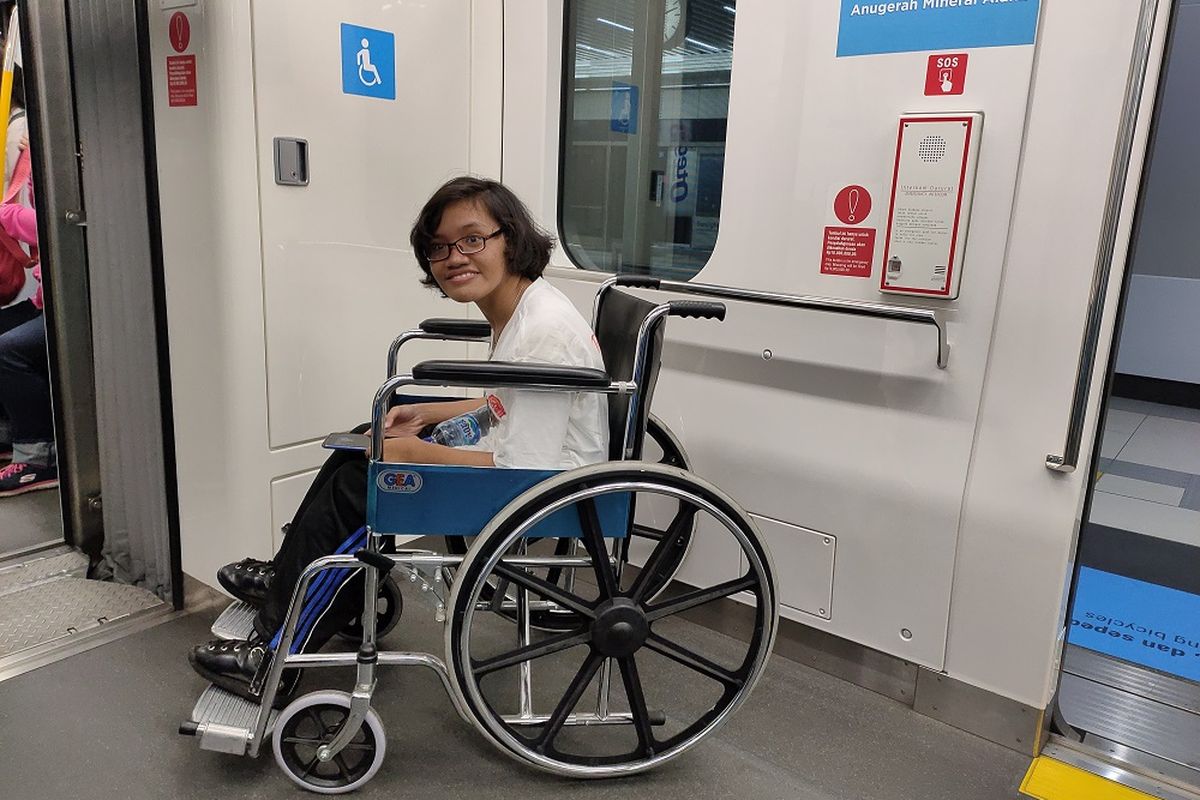 Maria (21), tengah mencoba fasilitas tempat khusus bagi penyandang disabilitas berkursi roda di dalam MRT, Selasa (3/12/2019).