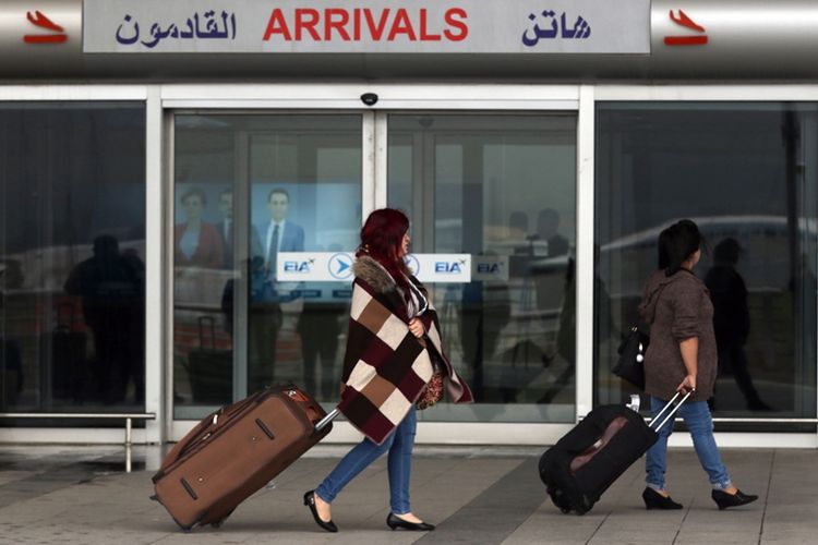 Calon penumpang melintas di luar bandara internasional Erbil di Kurdistan Irak. Pemerintah pusat Irak telah mencabut blokade udara di wilayah tersebut.