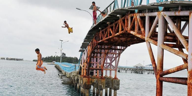 Anak-anak terjun ke laut dari Jembatan Cinta di Pulau Tidung, Kepulauan Seribu, Sabtu (14/3/2015). Jembatan Cinta merupakan salah satu ikon wisata di Pulau Tidung dan salah satu tujuan wisata utama di Kepulauan Seribu.