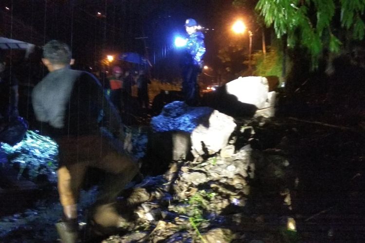 Pembersihan material longsor yang menutup badan jalan di jalur penghubung Pacet - Trawas, Kabupaten Mojokerto, Jawa Timur, dilakukan petugas dengan bantuan alat berat, Jumat (7/2/2020) malam.