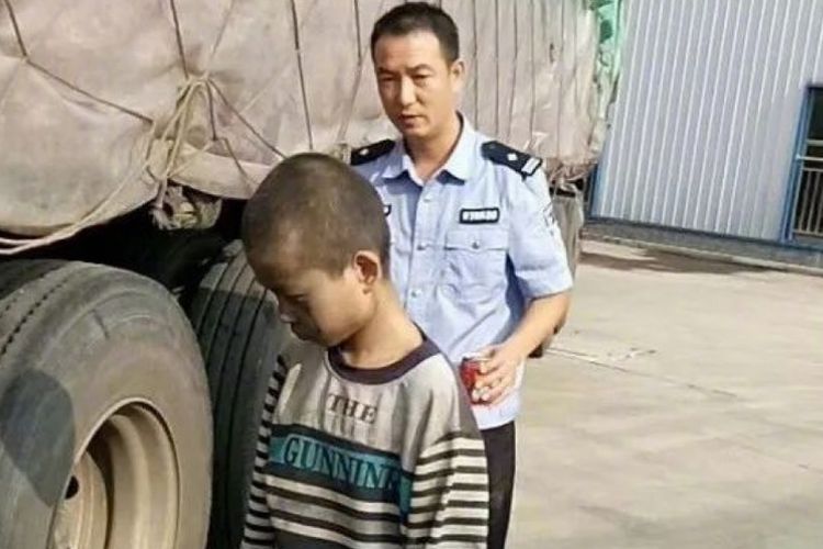 Petugas saat menemani Xiaoneng (9), bocah di China yang kabur dari rumah dengan menumpang di bawah sebuah truk.
