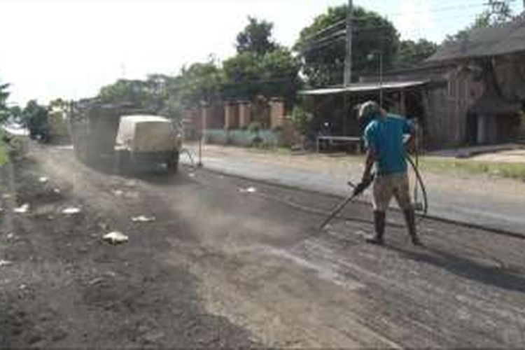 Pekerja tengah melakukan perbaikan jalan jalur Nasional yang berada di desa Kedunglurah Kecamatan Pogalan Trenggalek. (25/06/2016)