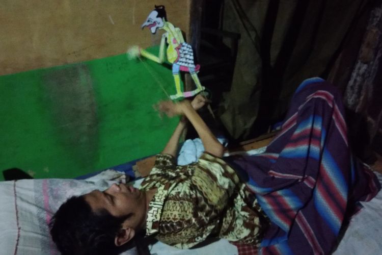 Untoro (60) warga Dusun Klampok, Desa Giripurwo, Kecamatan Purwosari, Gunungkidul, Yogyakarta, saat bermain wayang di sela beraktivitas belajar bersama anak-anak,  Rabu (30/1/2019) sore