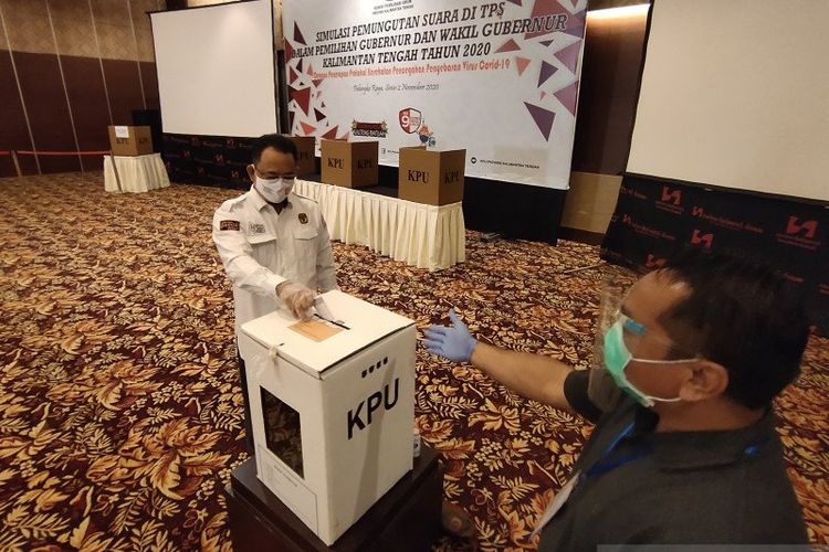 Ketua KPU Kalteng, Harmain Ibrohim (kiri) saat simulasi pemungutan suara berprotokol kesehatan COVID-19 di Kota Palangka Raya, Senin (2/11/2020).