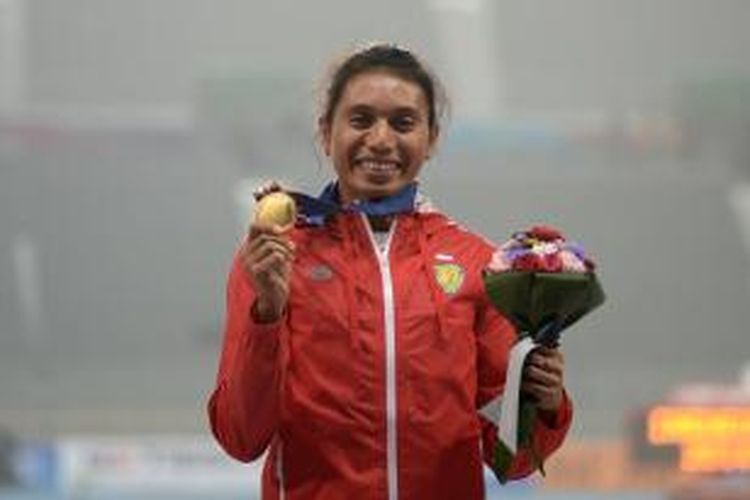 Atlet lompat jauh Indonesia, Maria Natalia Londa, berpose dengan medali emas yang dia dapatkan di Asian Games 2014 di Incheon, Korea Selatan, Senin (29/9/2014).