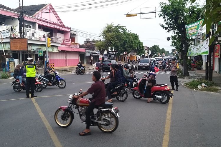 URAI KEMACETAN—Aparat Polres Madiun mengatur arus lalu lintas untuk mengurai kemacetan di simpang empat pagotan, Kecamatan Geger, Kabupaten Madiun, Jawa Timur, Jumat (6/5/2022) sore. 