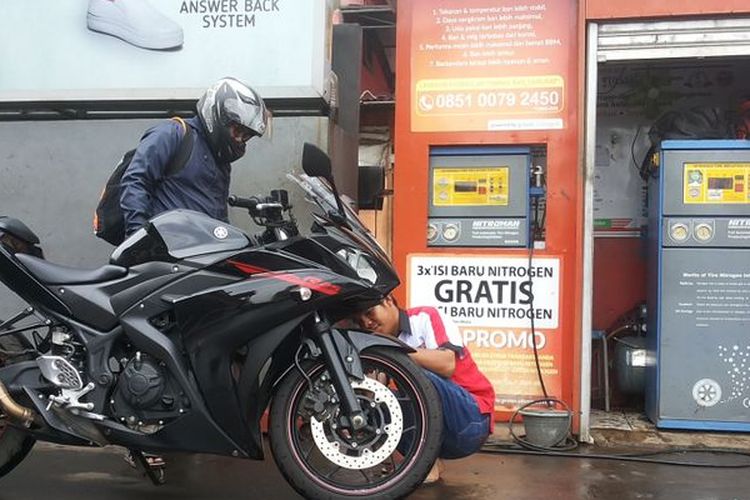 
Seorang petugas outlet pengisian ban dengan nitrogen di salah satu SPBU Pertamina di Jalan Margonda, Depok sedang melayani pelanggan pada Kamis (8/2/2018).
