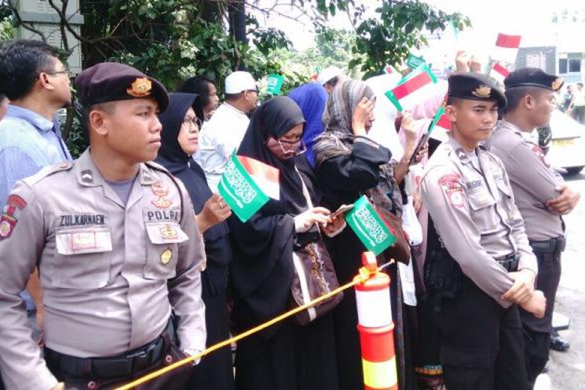 Puluhan warga dari berbagai daerah di Jakarta berdiri di luar pintu masuk Bandara Halim Perdanakusuma untuk menyambut kedatangan Raja Salman. Rabu (1/3/2017).