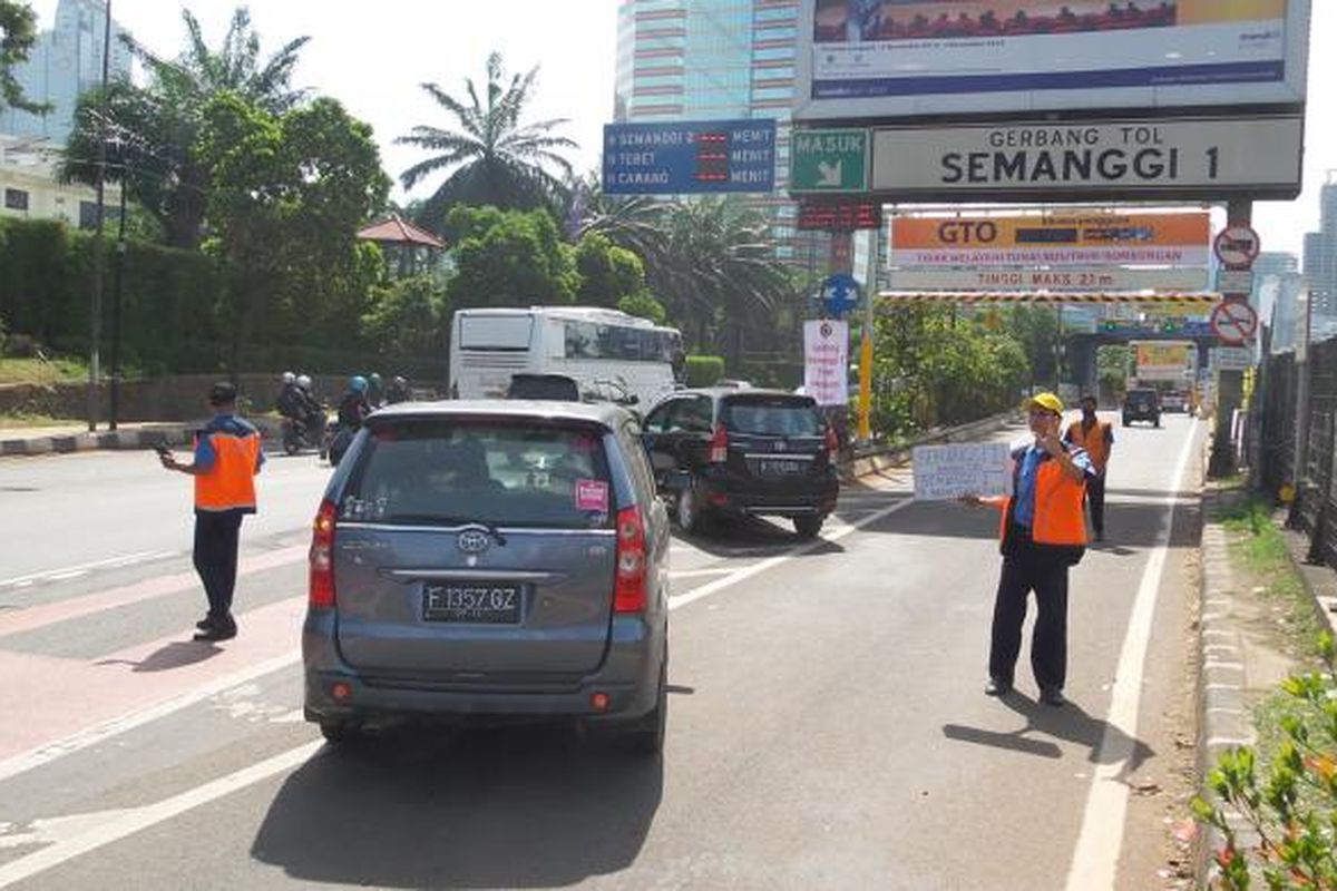 Sejumlah mobil yang tidak jadi masuk Gerbang Tol Semanggi I akibat tidak memiliki e-money, Rabu (17/12/2014). Terhitung sejak 16 Desember 2014, Gerbang Tol Semanggi I tidak lagi menerima transaksi tunai dan hanya melayani transaksi elektronik melalui penggunaan e-money.