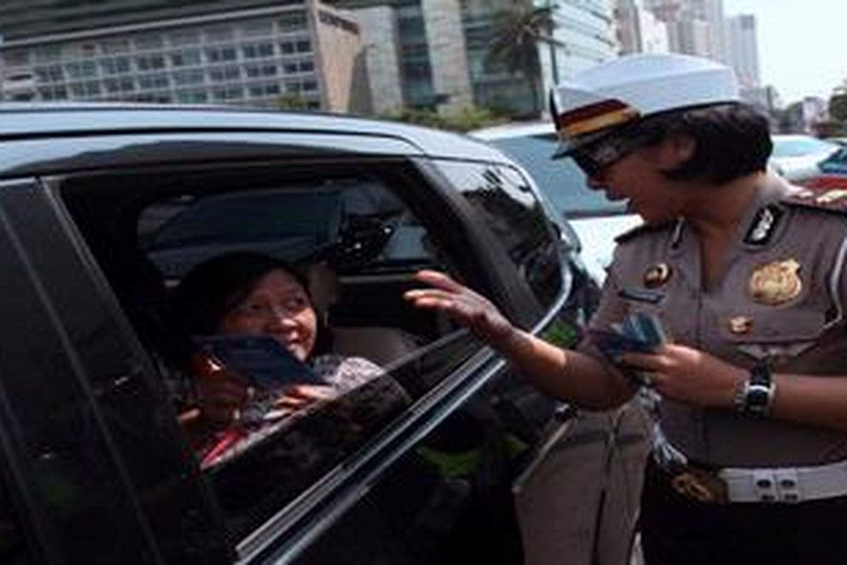 Polisi Lalu Lintas membagikan selebaran tips aman berkendara kepada pengguna jalan di Kawasan Bundaran Hotel Indonesia, Jakarta Pusat, Senin (6/5/2013). Selain untuk kampanye aman berkendara, aksi itu juga untuk sosialisasi Operasi Simpatik Kepolisian yang akan berlangsung selama 21 hari kedepan.
 
