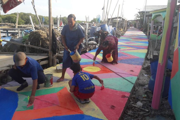 Warga bergotong-royont mengecat jalan di pemukiman RW 04 Kamal Muara, Jakarta Utara, Rabu (14/3/2018).