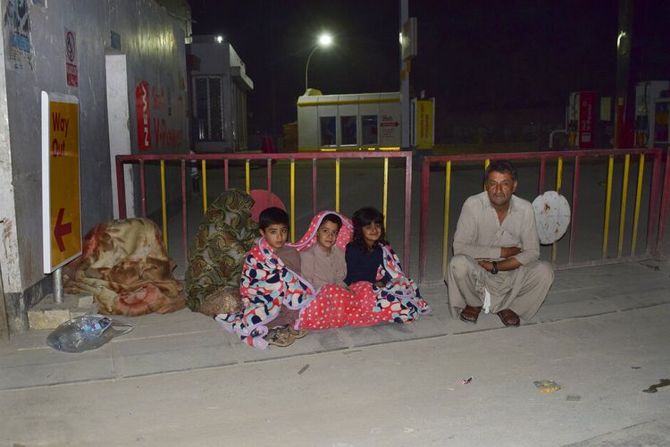 Keluarga berkumpul di luar rumah mereka setelah gempa bumi dahsyat melanda  Quetta, Pakistan, pada Kamis (7/10/2021). Gempa kuat mengguncang wilayah barat daya Pakistan pada Kamis dini hari waktu setempat.