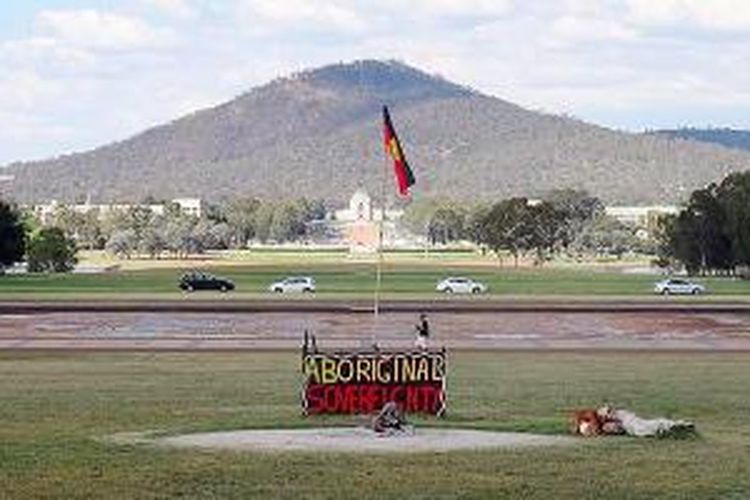 Protes orang Aborigin di lahan gedung parlemen yang tua. Protes atas pemberian izin pemerintah kepada sebuah perusahaan tambang di Northern Territory ini sudah berlangsung selama 42 tahun. Orang Aborigin menuntut hak atas tanah mereka. Di latar belakang tampak monumen Australian War Memorial.