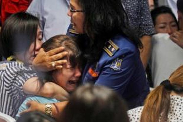 Keluarga penumpang pesawat AirAsia QZ 8501 bereaksi saat menerima informasi ditemukannya jenazah dan serpihan pesawat di crisis center Bandara Juanda, Surabaya, Selasa (30/12/2014). Pesawat AirAsia QZ8501 yang mengangkut 155 penumpang serta 7 awak, jatuh pada Minggu pagi.