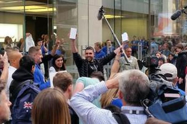 Salvatore Gerace, pembeli iPhone 6 pertama di dunia keluar dari Apple Store di Sydney, Australia, Jumat (19/9/2014).