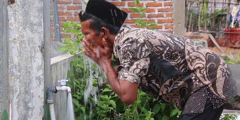 warga Dusun Pelita, Gampong Meunasah Mon, Krueng Raya, Kabupaten Aceh Besar sedang berwudhu di pekarangan rumah, selama ada bantuan sumur bor dari pertamina mereka tidak perlu lagi harus ke sungai untuk kebutuhan air sehari hari.