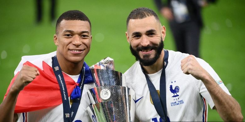 Kylian Mbappe (kiri) dan Karim Benzema (kanan) merayakan dengan trofi di akhir pertandingan sepak bola final UEFA Nations League antara Spanyol dan Perancis di stadion San Siro di Milan, pada 10 Oktober 2021.