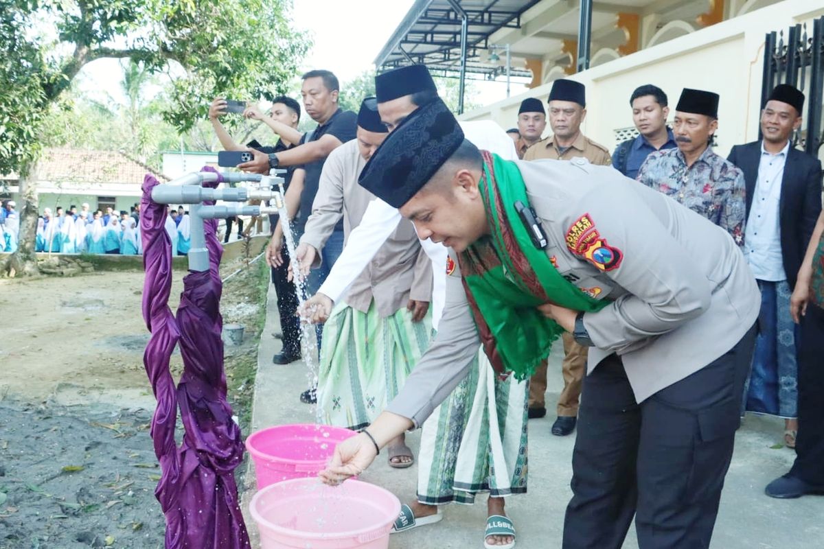 Kapolres Bangkalan mencoba keran air yang dialiri dari pengeboran air di Ponpes Al Hasany Desa Tlokoh, Kecamatan Kokop, Kabupaten Bangkalan, Senin (30/6/2025). 