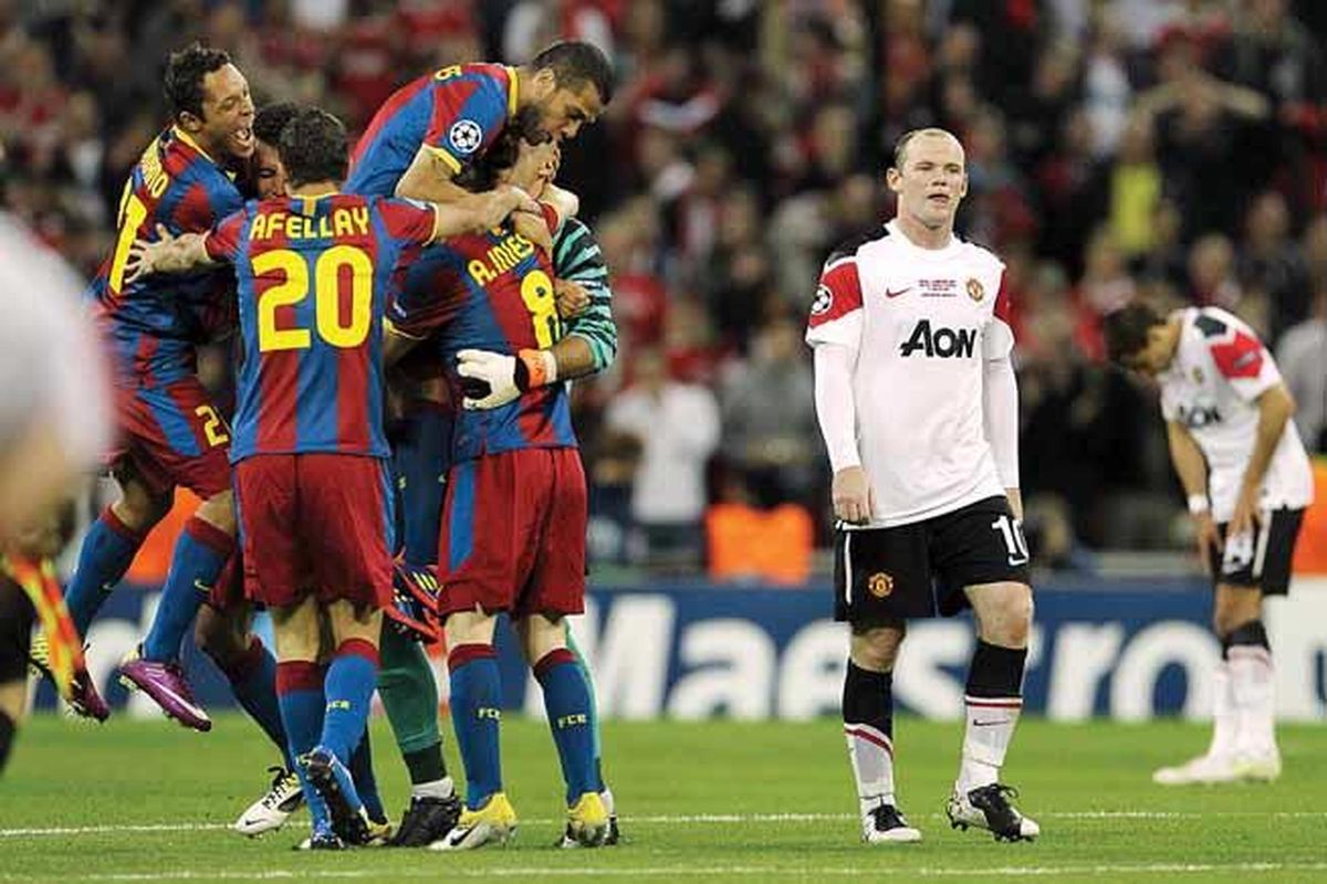 Striker Manchester United, Wayne Rooney (kanan), melangkah gontai, sementara pemain Barcelona berpelukan merayakan keberhasilan mereka menjuarai Liga Champions di Stadion Wembley, London, Inggris, Sabtu (28/4).