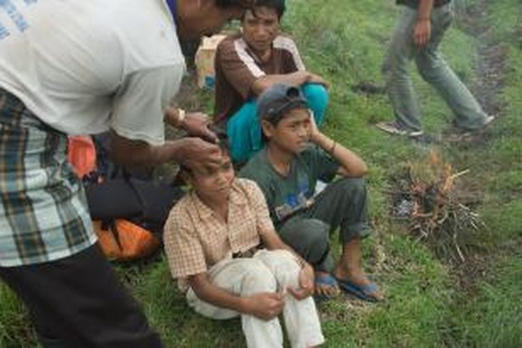 Upacara izin sebelum memasuki hutan di Bukit Kanji, salah satunya dengan menyentuhkan bawang tunggal ke kening setiap orang.