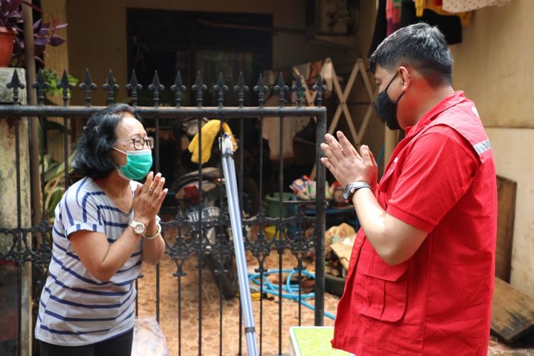 Direktur Human Capital Management Telkom Afriwandi (kanan) berbicang dengan warga terdampak banjir di wilayah Pondok Karya, Kelurahan Pela Mampang, Kecamatan Mampang Prapatan, Senin (22/2). Selain memastikan keamanan perangkat jaringan, sebagai bentuk dukungan kepedulian kepada masyarakat, Telkom juga turut memberikan bantuan kepada masyarakat yang terdampak banjir berupa paket sembako, alat kebersihan, dan disinfektan.