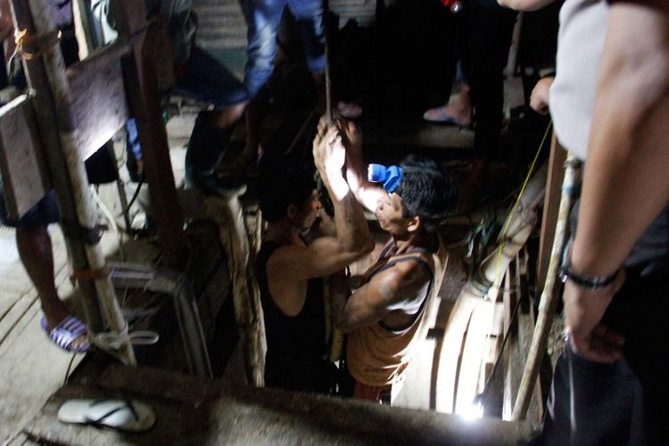 Petugas penyelamat mencoba memasuki lubang masuk vertikal untuk menyelamatkan 13 penambang yang terjebak di dalam lubang tambang emas di Minahasa Utara, Kamis (13/4/2017).