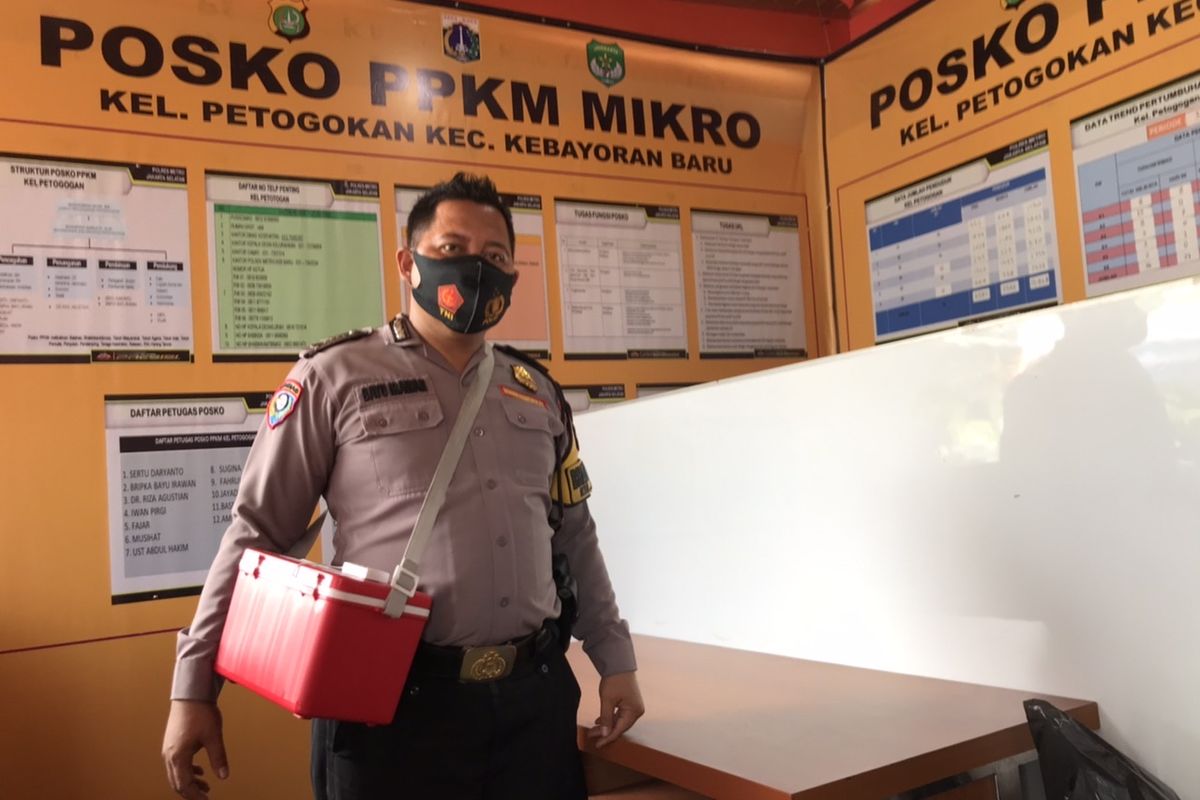 Bhabinkamtibmas Polsek Metro Kebayoran Baru yang bertugas di Kelurahan Petogogan, Bripka Bayu Irawan (36) berada di Posko PPKM Kelurahan Petogogan, Kebayoran Baru, Jakarta Selatan pada Selasa (17/8/2021).