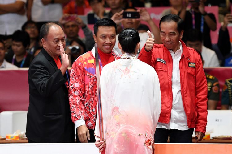 Presiden Joko Widodo (kanan) didampingi Menpora Imam Nahrawi (kedua kiri) memberi ucapan selamat kepada atlet Indonesia Lindswell (kedua kanan) usai bertanding dalam nomor Taijijian Putri Wushu Asian Games 2018 di JIExpo, Kemayoran, Jakarta, Senin (20/8/2018). ANTARA FOTO/INASGOC/Ismar Patrizki/nak/18.