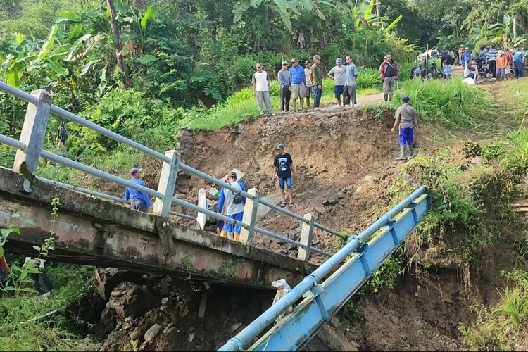 Sejumlah warga di Desa Jabranti Kecamatan Karangkencana Kabupaten Kuningan tidak dapat melintasi jembatan Cirombeng, yang roboh pada Sabtu petang (8/4/2023). Jembatan ini mengakibatkan 2.200 warga terisolasi karena merupakan akses utama dan satu satunya yang dapat dilintasi warga.