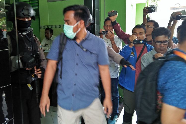 Salah seorang tim penyidik dari KPK, saat bergegas keluar meninggalkan Kankemenag Gresik usai penggeledahan di ruang kepala Kankemenag, Rabu (20/3/2019). 