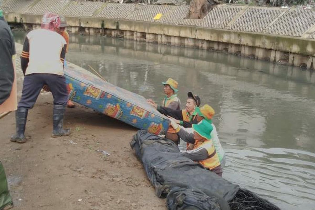 Tim UPK Badan Air Jakarta Barat mengangkat sampah kasur yang ditemukan di alirang kali Grogol, Jakarta Barat, Kamis (7/3/2019). 