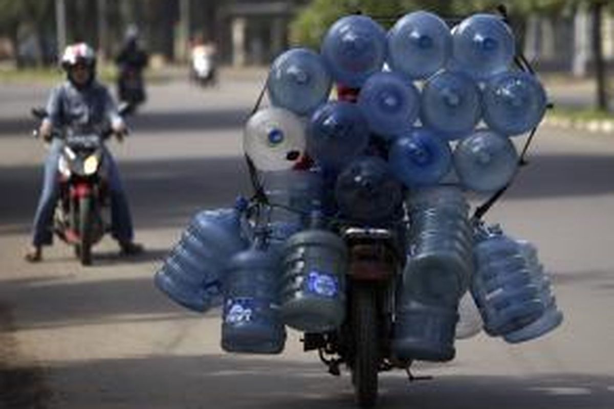 Ilustrasi: Pekerja membawa galon minuman air minum dengan saling diikat di atas sepeda motor di Jalan Raden Inten, Jakarta Timur, Senin (16/1/2012).