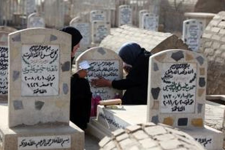 Seorang perempuan Irak mendatangi makam keluarganya di hari raya Idul Adha. Sebuah survei menyebut korban tewas akibat perang dan kekerasan di Irak sejak invasi AS pada 2003 hingga 2011 mencapai 460.000 orang.