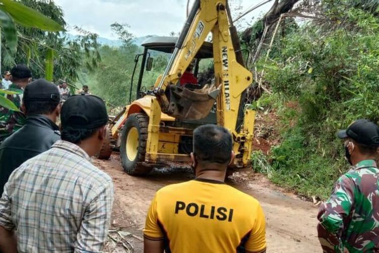 Personel gabungan membersihkan material longsor yang menimbun jalan penghubung Sumedang-Garut di wilayah Cibugel, Sumedang, Jawa Barat, Senin (21/12/2020). AAM AMINULLAH/KOMPAS.com