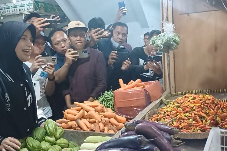 Istri calon presiden (Capres) nomor urut 3 Ganajr Prnaowo, Siti Atikoh Supriyanti mendengar keluhan para pedagang sembilan bahan pokok (Sembako) di Madiun, Jawa Timur yang mengalami kenaikan harga karena pasokan kurang, Senin (18/12/2023).