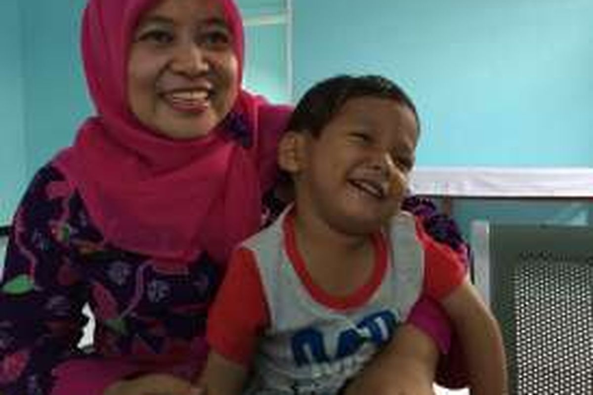 Marcel (3), anak yang ditinggal pergi orangtua tengah berada dipangku petugas di Rumah Singgah Dinsos Kota Tangerang, Kamis (5/1/2017).
