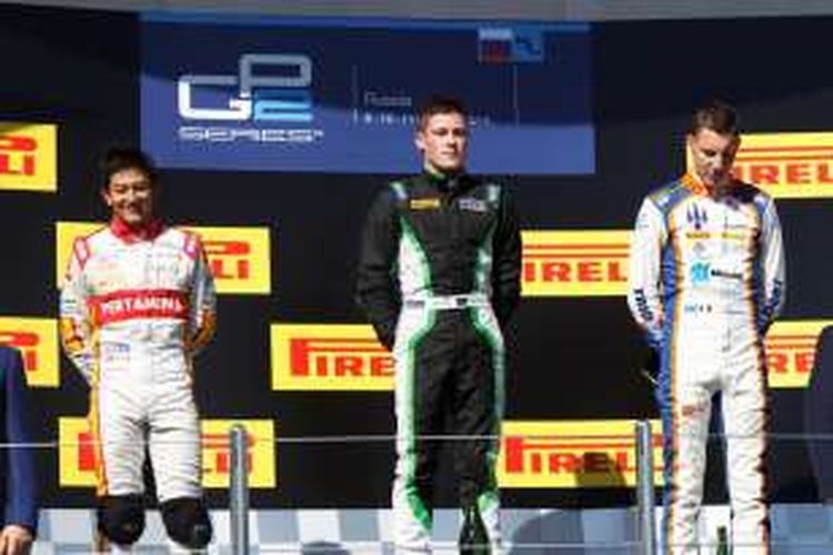 Pebalap Campos Racing asal Indonesia, Rio Haryanto (kiri), tersenyum di atas podium Sirkuit Sochi setelah finis di urutan kedua pada balapan GP2 Series Rusia, Minggu (10/11/2015).