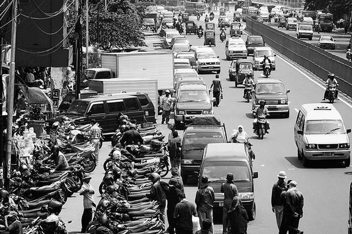 Ratusan motor dan mobil diparkir di salah satu lajur di Jalan Matraman Raya, tepatnya di sekitar Pasar Jatinegara, Jakarta Timur, Rabu (16/4). Kurangnya lahan parkir dan banyaknya kendaraan membuat warga menggunakan badan jalan sebagai tempat parkir.  
