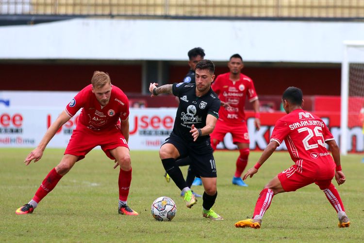 Pemain Persebaya Surabaya Higor Vidal dijaga ketat pemain Persija Jakarta di menit akhir pertandingan pekan ke-15 Liga 1 2022-2023 yang berakhir dengan skor 1-1 di Stadion Maguwoharjo Sleman, Jumat (16/12/2022) sore.