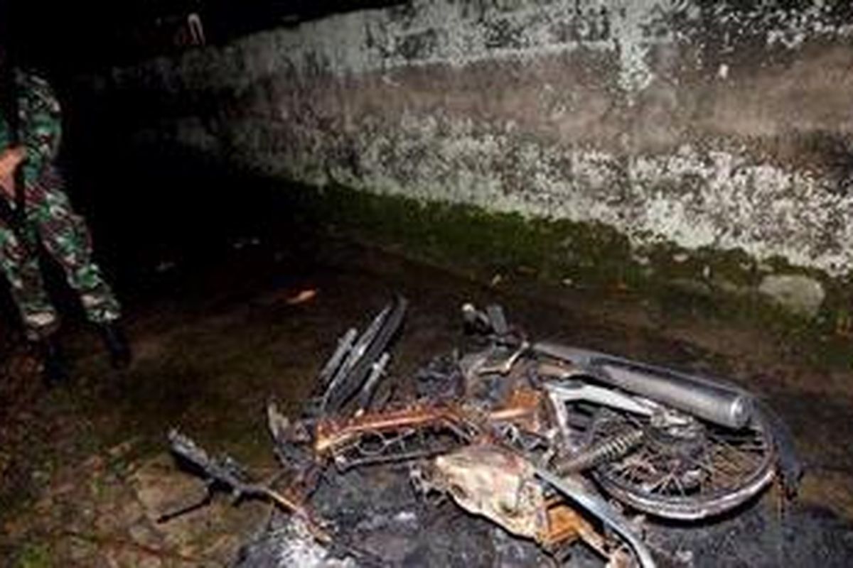 Anggota TNI berada di dekat puing sepeda motor yang dibakar massa di Ciampea Udik RW 05, Kecamatan Ciampea, Kabupaten Bogor, Jawa Barat, Sabtu (2/10/2010). Massa menyerang desa yang dihuni sekitar 500 jemaah Ahmadiyah, menghancukan belasan rumah dan membakar dua rumah dan satu masjid.