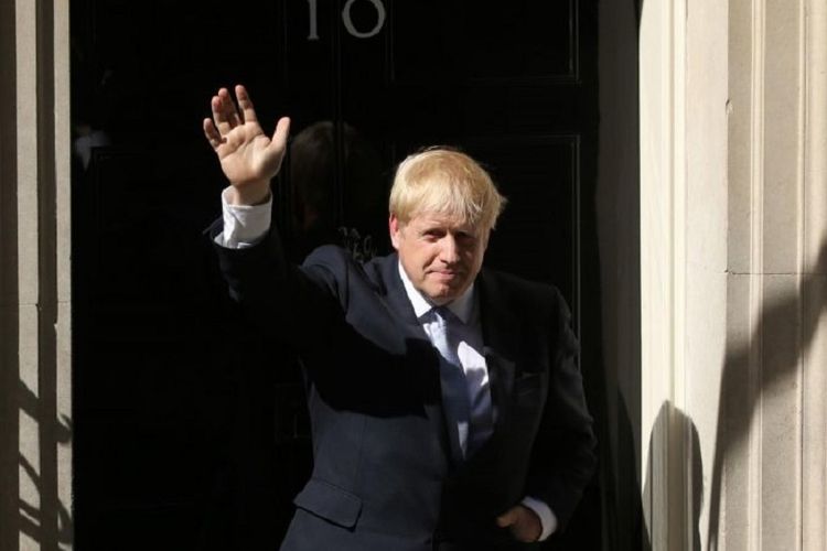 Perdana Menteri Inggris Boris Johnson melambaikan tangan di depan kediaman resmi perdana menteri di 10 Downing Street, setelah resmi dilantik dan menyampaikan pidato pertamanya.