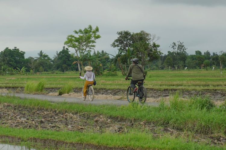 Dokumentasi wisatawan bersepeda menyusuri jalanan Desa Bilebante, Lombok Tengah.